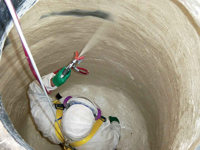 Manhole with man spraying anticorrosive coating