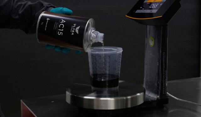 A painter pouring Ultra System product in a mixing cup
