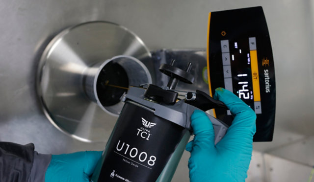 A painter pouring Ultra TC1 product in a mixing cup on a weighing scale