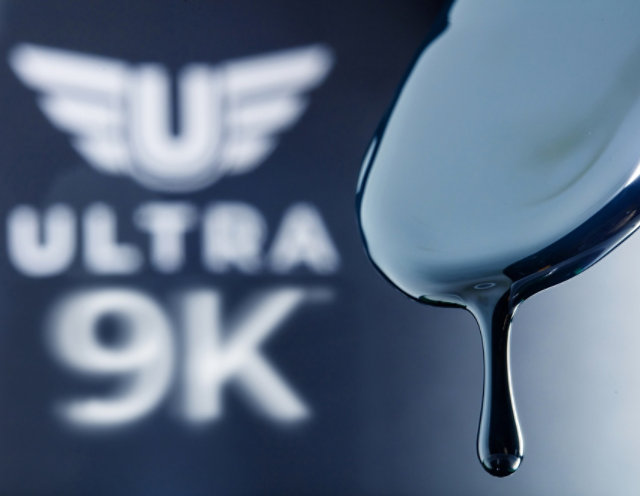 Ultra 9K toner drips from mixing stick with the logo in the background
