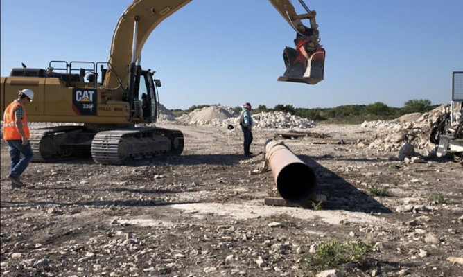 crane dropping rock on pipe for testing