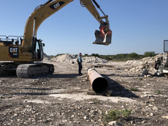 crane dropping rock on pipe for testing