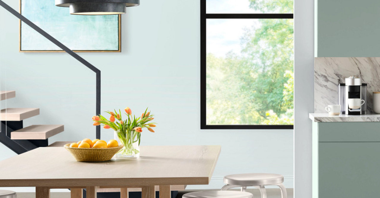 Modern kitchen with painted wood cabinetry in soft green and matte finishes.