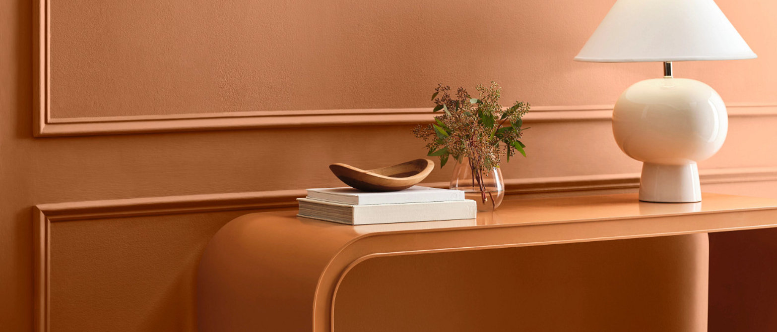 Home office with painted wood furniture and layered warm pink wall colors.