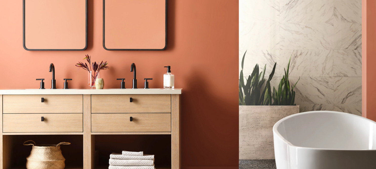 Bathroom with painted wood vanity and warm terracotta-colored walls.