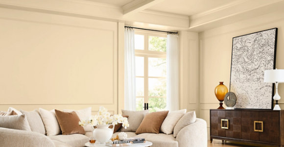 Elegant living room featuring a neutral-toned sectional sofa, wooden furniture with a smooth finished surface, and warm natural light, showcasing a refined wood interior aesthetic.