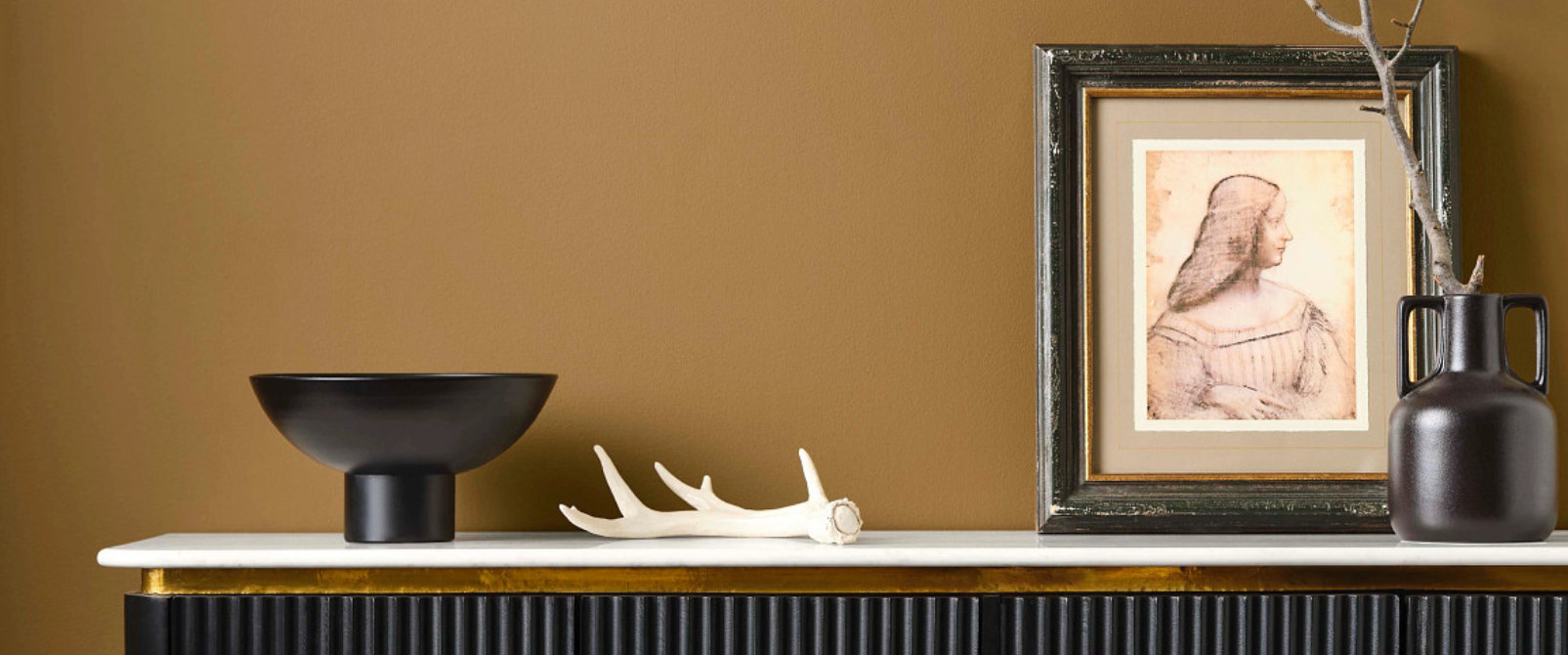 Close-up of painted wall surface in warm bronze tone with console table detail.