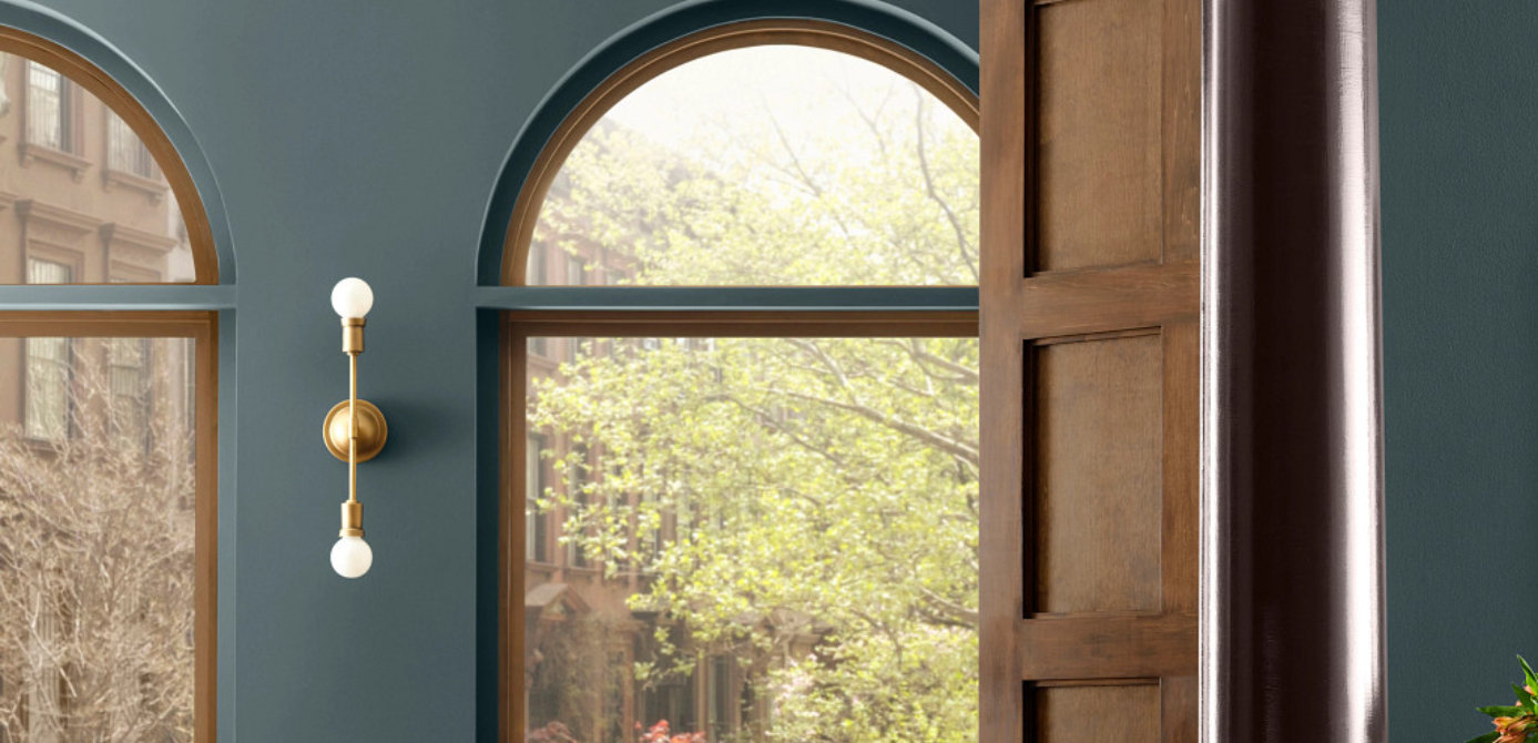 Entry living area with painted walls in deep green tone and wood furniture accents.