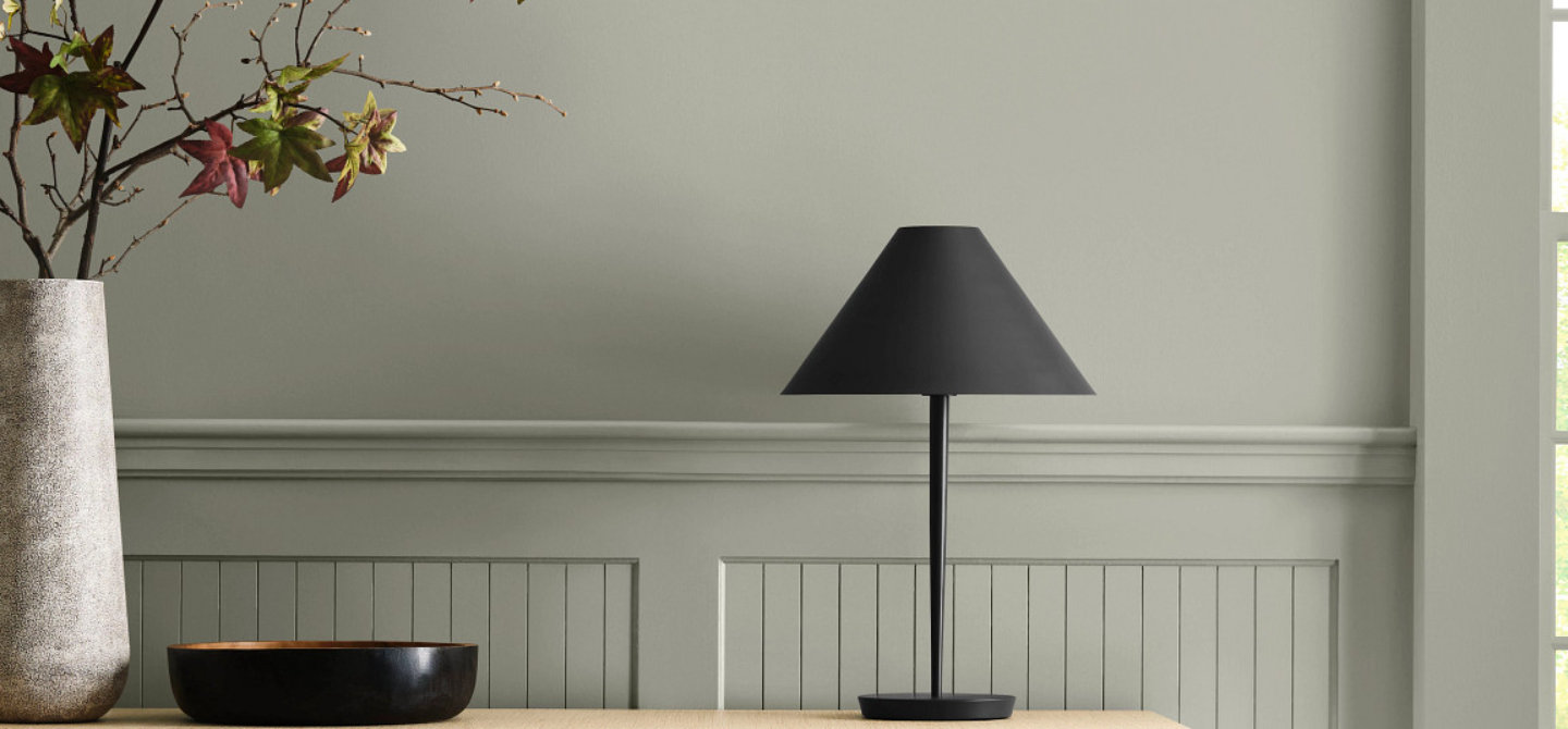 Painted wall detail in soft gray tone with wood console and decorative objects.