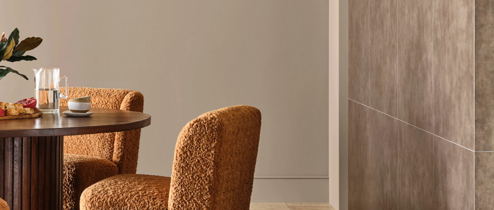 Dining area with painted walls in warm neutral tone and wood table with upholstered chairs.