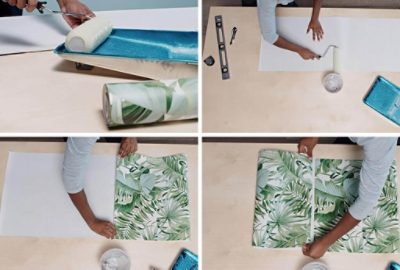 Wallpaper adhesive in a paint tray and being applied to the back of wallpaper with a roller.