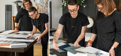 Sue Wadden and Christian Siriano bent over a large wooden table scattered with Sherwin-Williams paint samples, choosing colors for the new collection.