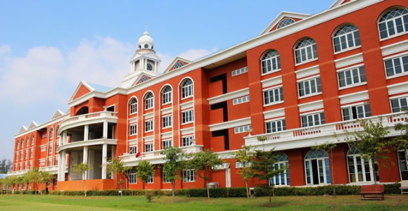A large red-brick building with white accents, arched windows, and a central tower topped with a dome