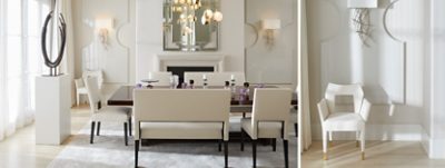 Elegant modern dining room with large sculpture on a white pedestal, custom wall panels with white chairs and a glossy black dining table with scattered purple glassware and candleholders on top.