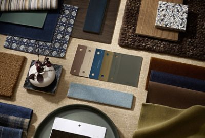 Flat lay featuring paint color samples, fabric swatches, wood and tile samples, and accessories in a range of neutral, blue and green tones.