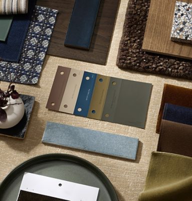 Flat lay featuring paint color samples, fabric swatches, wood and tile samples, and accessories in a range of neutral, blue and green tones.
