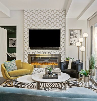 Stylish living room with TV, electric fireplace, and modern furniture featuring a geometric patterned accent wall, surrounding walls painted Sherwin-Williams Pure White, and large windows. 