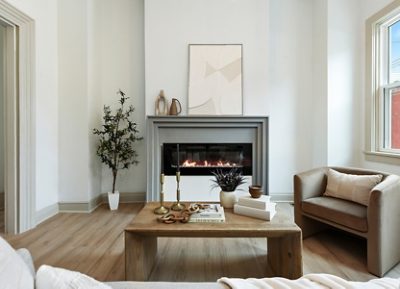 Modern living room with electric fireplace, neutral furniture, and large windows painted in Sherwin-Williams Pure White and Accessible Beige. 