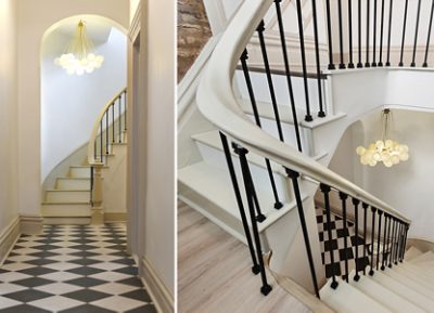 Two different angles of a spiral staircase with black railings, white steps, and a spherical light chandelier, featuring Sherwin-Williams paint in the colors Pure White and Accessible Beige.