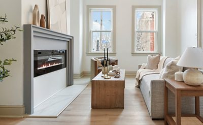 Modern living room with electric fireplace, neutral furniture, and large windows painted in Sherwin-Williams Pure White and Accessible Beige.