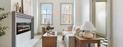 Modern living room with electric fireplace, neutral furniture, and large windows painted in Sherwin-Williams Pure White and Accessible Beige.