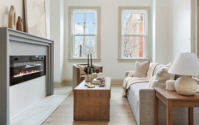 Modern living room with electric fireplace, neutral furniture, and large windows painted in Sherwin-Williams Pure White and Accessible Beige.