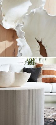 Close-up of white ceramic bowls with ruffled edges on a wooden table, and a modern living room with a white sofa behind a textured round pedestal coffee table.