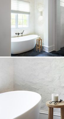 Modern bathroom with a freestanding bathtub, textured walls painted Sherwin-Williams Cotton, and stone tiles.