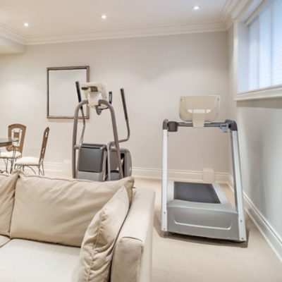 A fitness area in a basement with light gray walls.