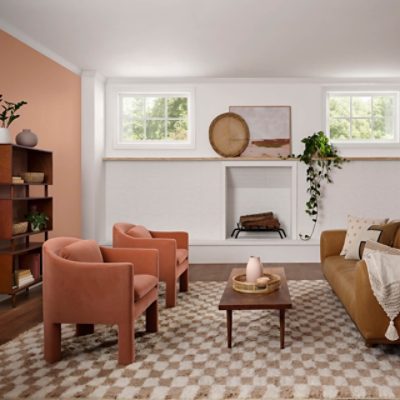 A basement with white and peach walls and retro decor and furniture.