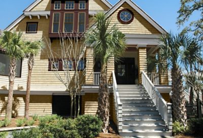 A yellow beach house with mahogany colored trim. S-W colors featured: SW 6135, SW 6137, SW 2838