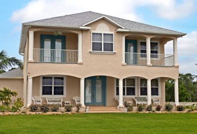 A tan beach house with brown roofing. S-W colors featured: SW 7012, SW 7713, SW 6222