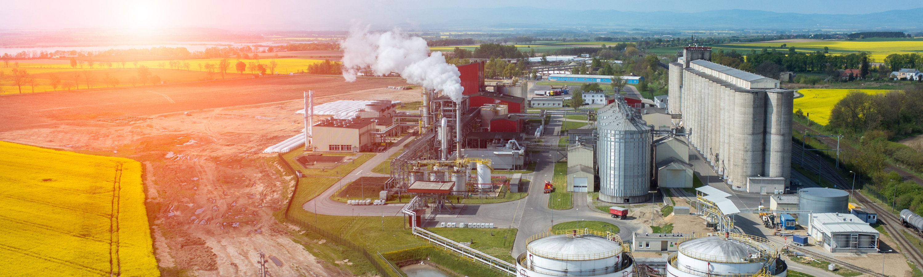 aerial view of a biofuel refinery with green fields