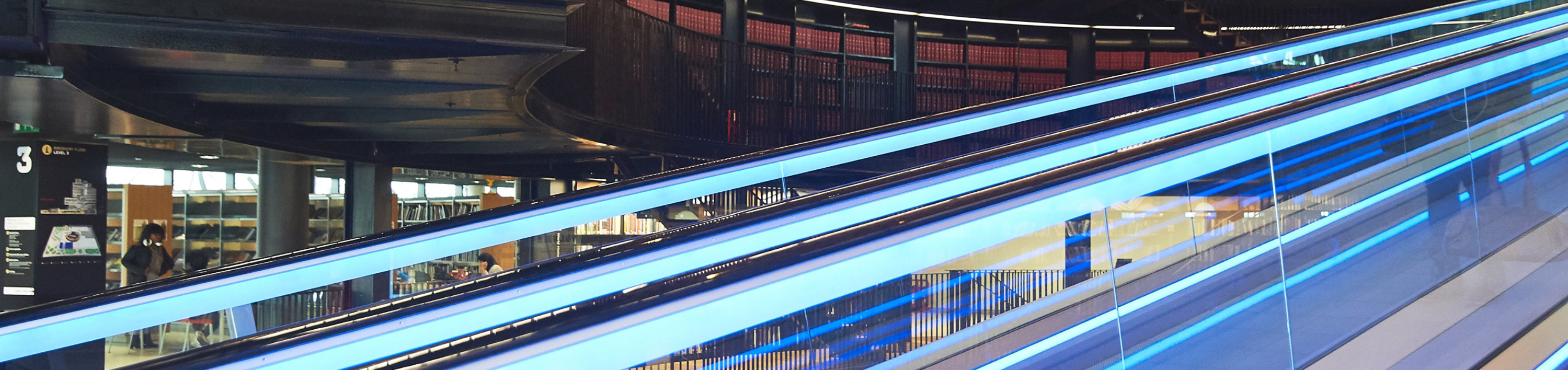 Image of a library with wood panelling and a metal escalator