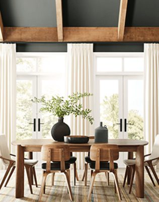 Dining room with large windows and seating with table.