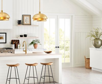 Una cocina luminosa con puertas francesas y una isla con taburetes.