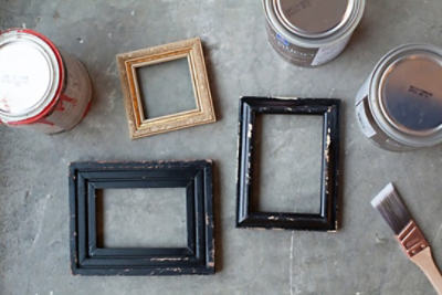 A set of three unpainted picture frames and cans of paint