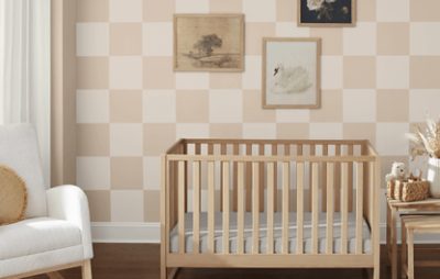 Nursery painted in a checkered pattern with Sand Dollar SW 6099, paintings, rocking chair, and crib.