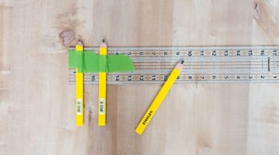 A set of carpenter pencils, tape and a ruler. 