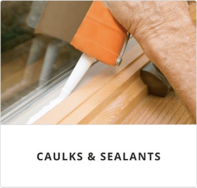 Person sealing a window sill with caulk.