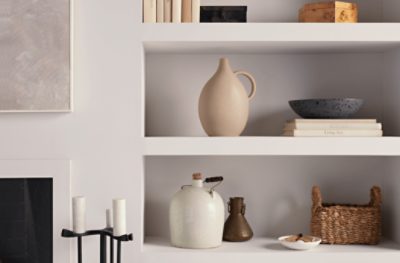 Ceramic vases placed on built in shelves painted Eider White SW 7014.