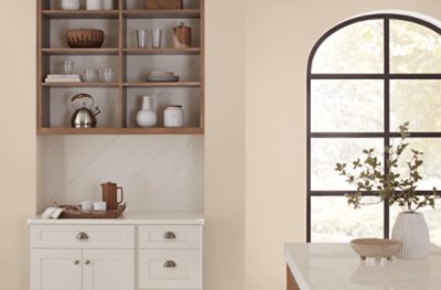 Kitchen walls painted in SW 6099 Sand Dollar with a large window and island.