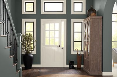 A foyer and staircase painted in SW 7622 Homburg Gray with a white front door.
