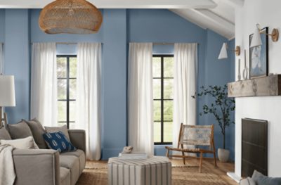 A living room with a vaulted ceiling and a white brick fireplace painted Aleutian SW 6241.