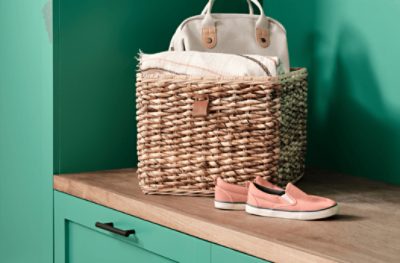 A pair of shoes and a wicker basket sitting on top of the wood bench of the entryway built-in painted Alexandrite SW 0060.