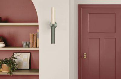 A living room with a built-in arched shelves and a door both painted Toile Red SW 0006.