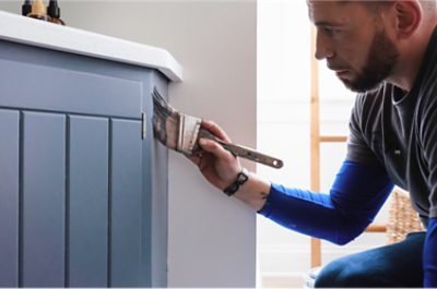  A person painting a cabinet.