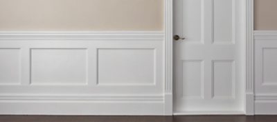 An interior hallway with a white painted door and wall. 