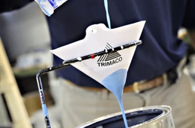 Pouring blue paint through a Trimaco cone paint strainer.