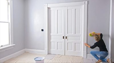 A woman cleaning walls before painting with a sponge. 